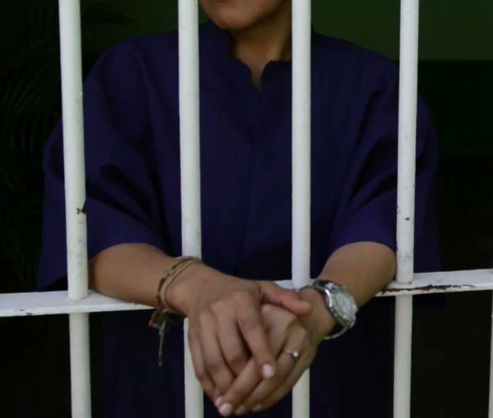 Hands on prison bars