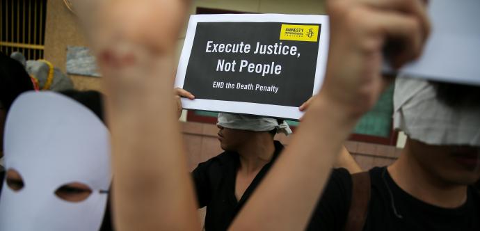 Une pancarte en anglais où y est inscrit «Execute Justice, Not People»
