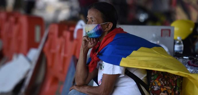 Un personne drapée du drapeau de la Colombie lors d'une manifestation.