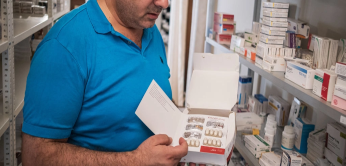 Une personne tient une boite de médicaments 