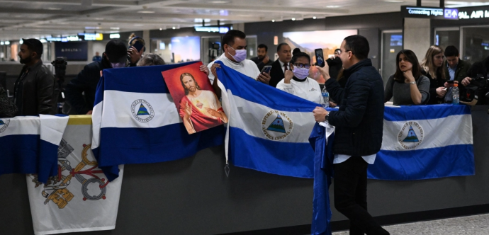 Des personnes qui attendent dans un aéroport avec des drapeaux du Nicaragua