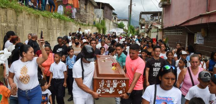 Une foule de personnes autour d'un cercueil