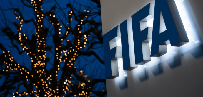 Le logo épelant FIFA est situé à droite, tandis qu'en arrière-plan se dresse un arbre illuminé.