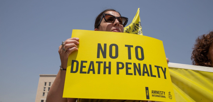 Une femme tenant une pancarte "Non à la peine de mort"