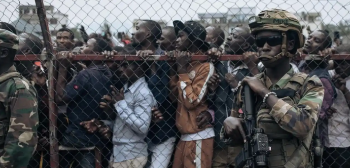 hommes derrière grillage et soldats