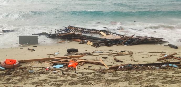 Bord de plage où se situent des débris de bois et de plastique.