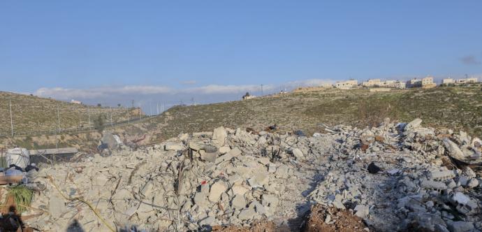 Champ de ruines avec un village au loin