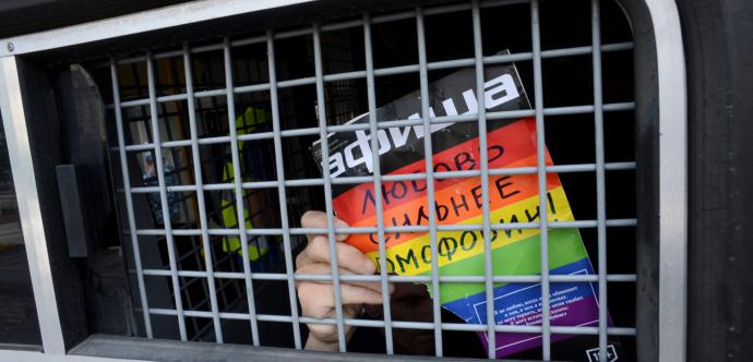 Affiche aux couleurs de la communauté LGBTI déchirée avec du texte en russe.