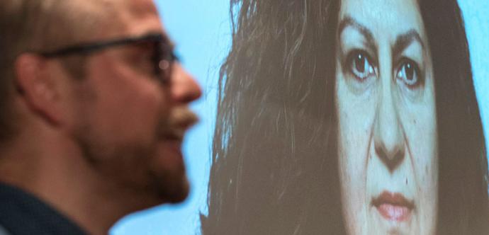 On voit le visage de la militante sur un écran géant