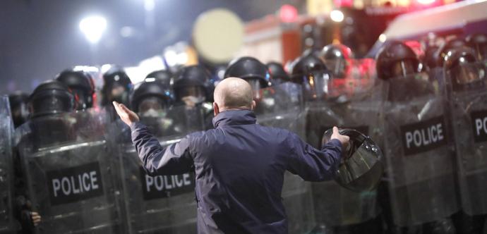 un homme se tient devant une foule de policiers