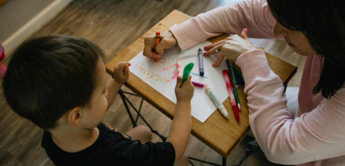 femme qui dessine avec un enfant dans une garderie