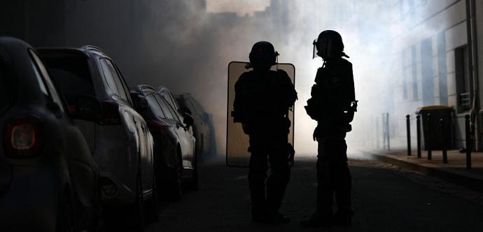 Riot police stand amid tear gas smoke during clashes with protesters on the sidelines of a demonstration of high-school students as part of a nationwide protest movement over learning conditions in Lyon, on October 6, 2026.