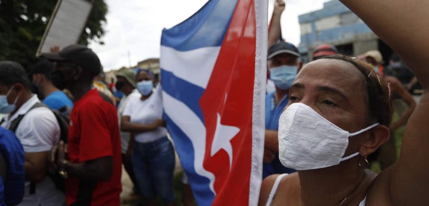 une manifestation à Cuba. Une personne tient le drapeau cubain.
