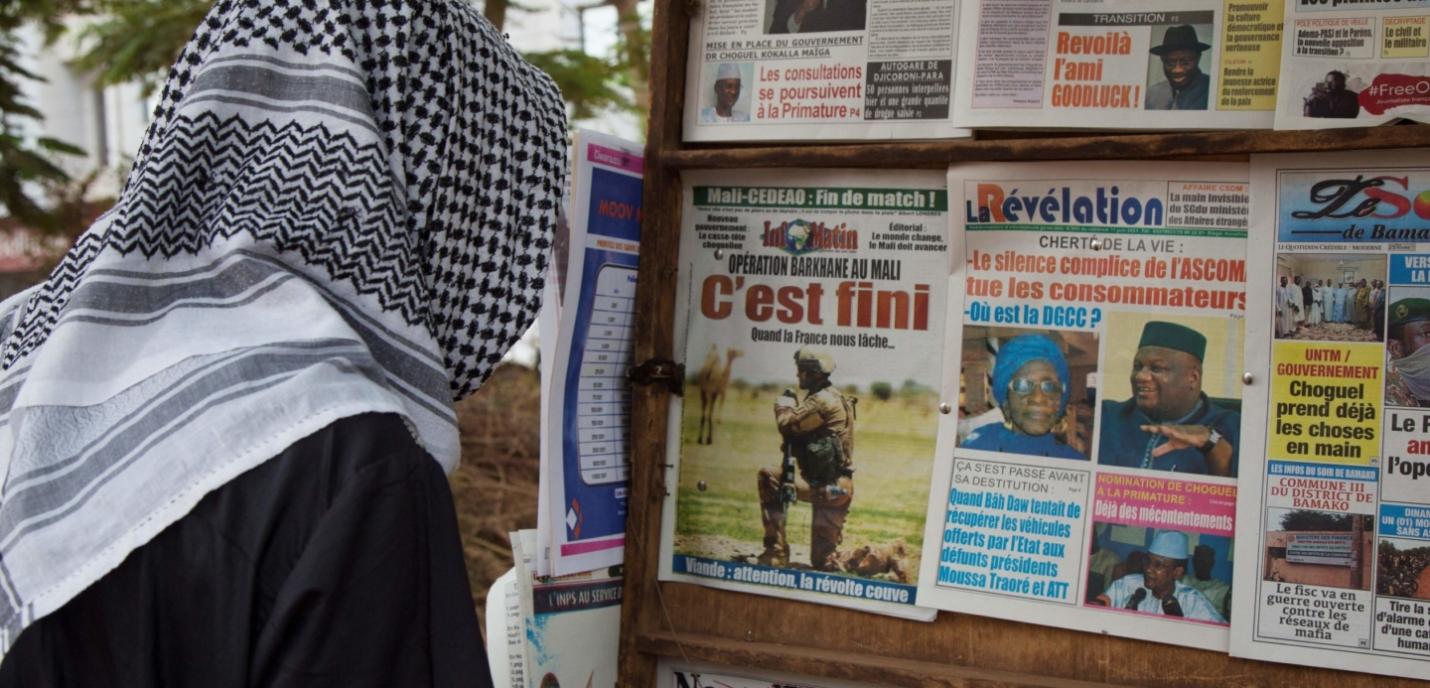 Une personne devant des journaux