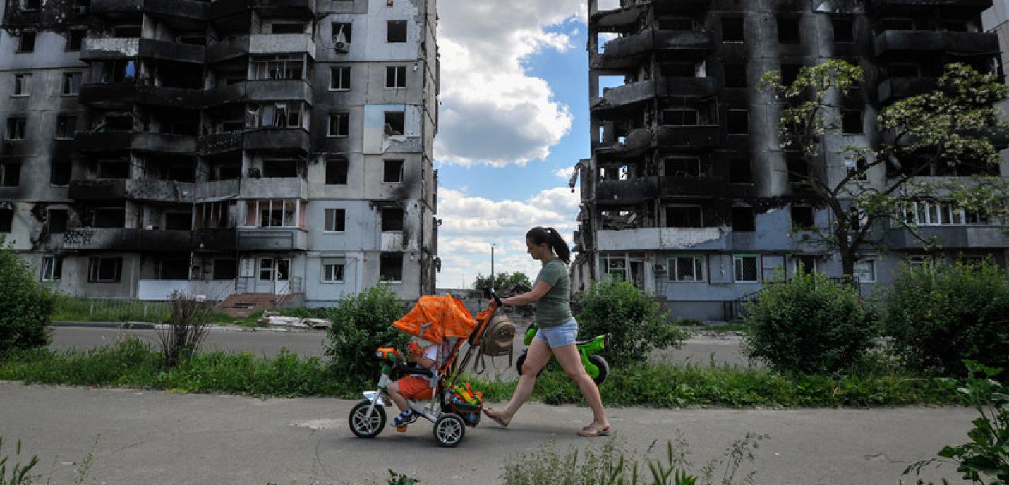 femme marche avec poussette sous les bombes