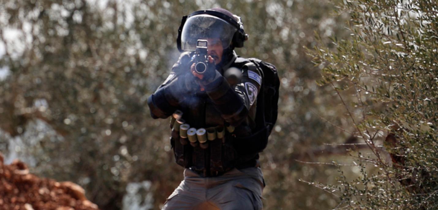 Un garde aux frontières israéliennes tirant des balles de caoutchouc