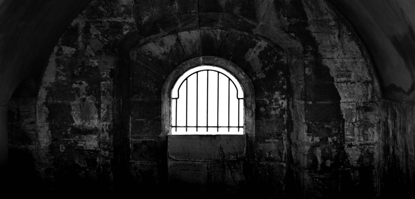 Une cellule de prison sombre avec une fenêtre avec de la lumière