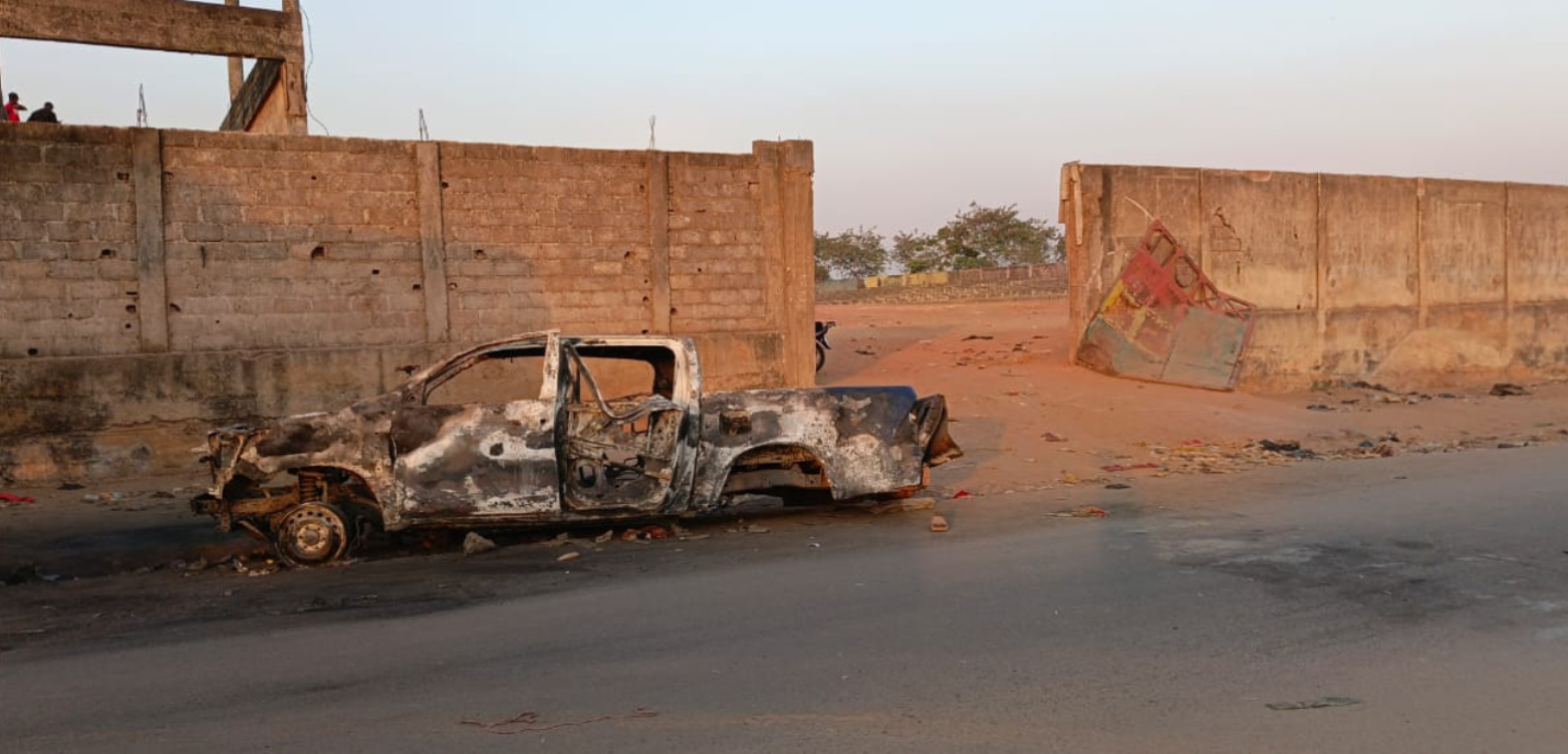 Une voiture brûlée au bord d'une route