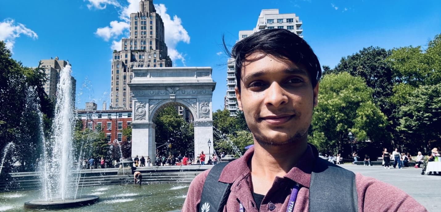 Maung Sawyeddollah (homme) prend un selfie devant l'Arche et la fontaine de la place Washington à Manhattan, New York