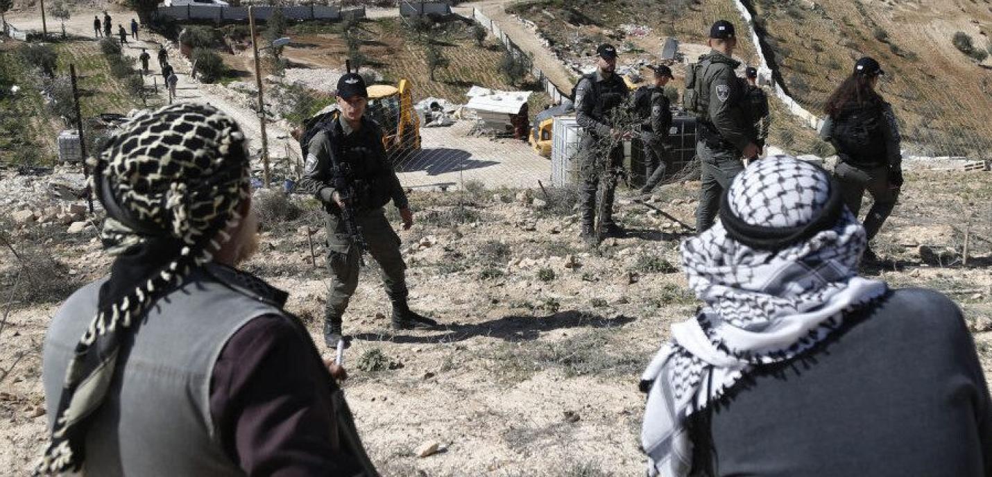 Soldats devant personnes palestiniennes