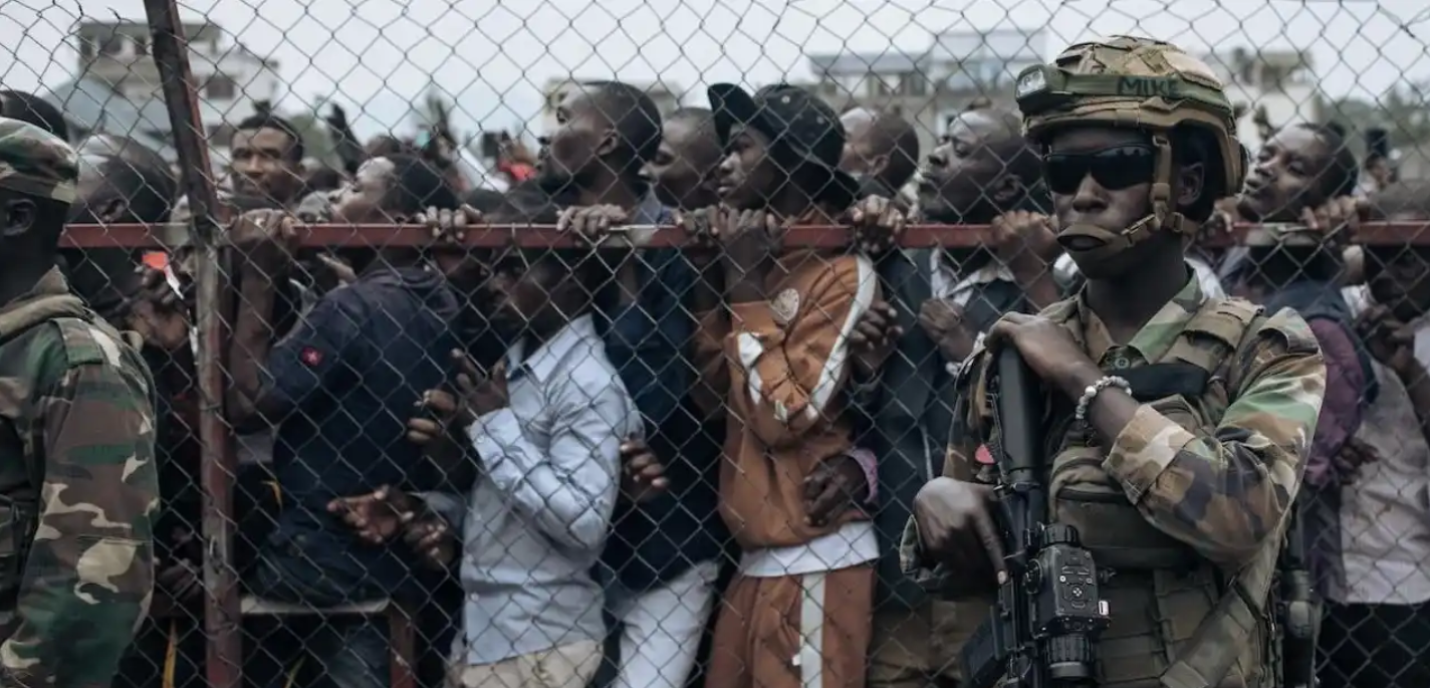 hommes derrière grillage et soldats