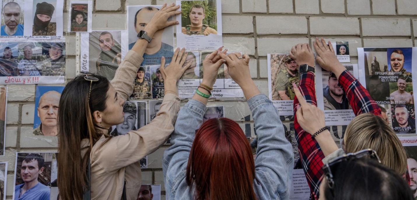 Photo de femmes accrochants des photos de soldats ukrainiens