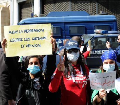 Des manifestant·e·s sont rassemblé·e·s et tiennent une pancarte écrite en français : «A bas la repression liberez les detenus d'opinion» et une autre en arabe.