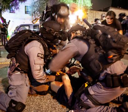 Trois policiers israéliens immobilisent un citoyen palestinien à Haifa lors d'une manifestation le 9 mai 2021.