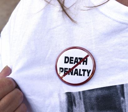 Une manifestante porte un macaron contre la peine de mort