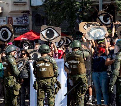 Des Carabineros devant une foule de manifestant·e·s