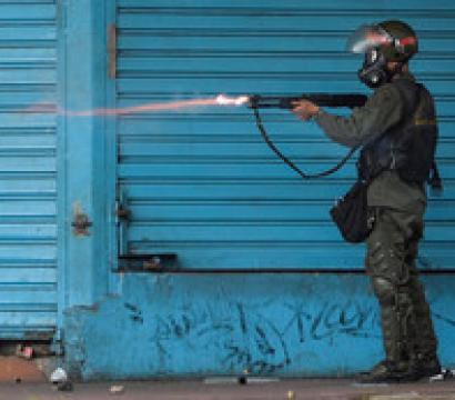Un policier anti-émeute tire des balles sur des manifestants lors d'une manifestation contre le gouvernement du président Nicolas Maduro