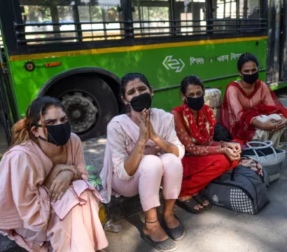 Des femmes avec un masque devant un autobus 