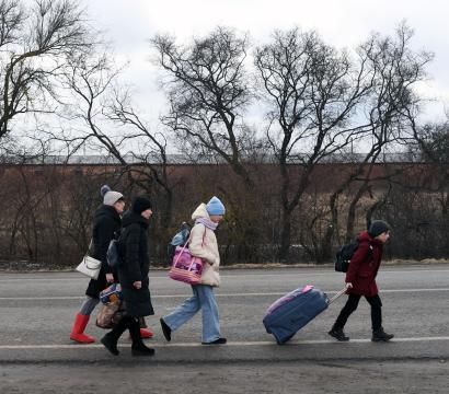 Des migrants marchent sur une route avec leurs affaires 