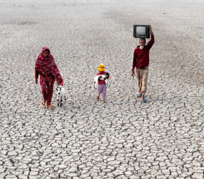 Une femme, un homme et un enfant marchent dans un désert solitaire.