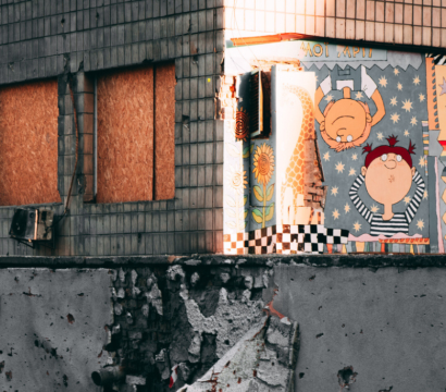 Un bâtiment endommagé par le feu, avec des dessins d'enfants sur un côté du mur.