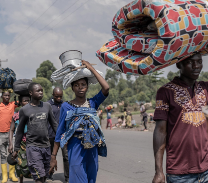 Des personnes transportent certains de leurs biens alors qu'elles fuient le territoire de Masisi suite aux affrontements entre les rebelles du M23 et les forces gouvernementales, sur une route près de Sake.