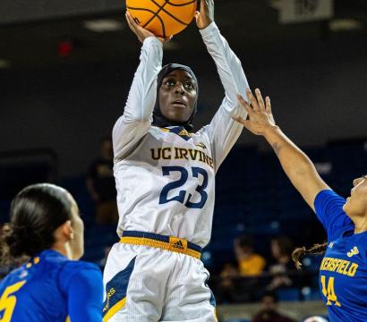 Une joueuse de basketball portant un hijab, en plein saut, bras tendu vers le panier.