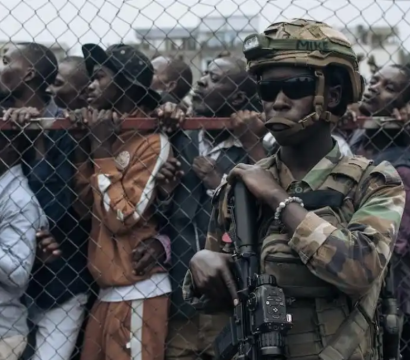hommes derrière grillage et soldats