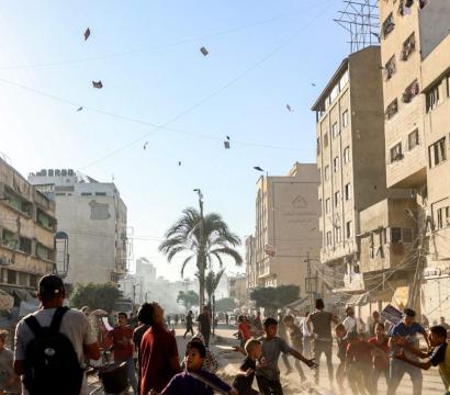 des choses qui tembent du ciel dans une ruelle avec des batiments détruits à gaza 