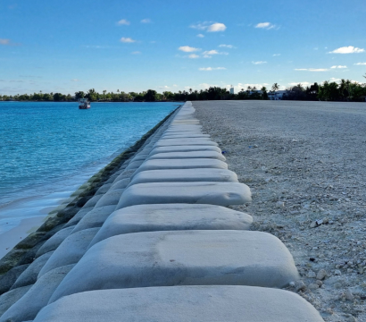 Un projet de récupération de terres à Funafuti, prévu pour durer environ 25 ans, consiste à draguer du sable dans le lagon, à le placer dans de grands sacs qui restent en place jusqu’à un an avant que des plants soient plantés, puis, finalement, à construire des bâtiments afin que des personnes puissent s’installer sur cette nouvelle terre. Tuvalu est une nation insulaire du Pacifique dont la population subit directement les effets d’un climat déstabilisé – notamment l’érosion côtière, l’inondation par l’ea