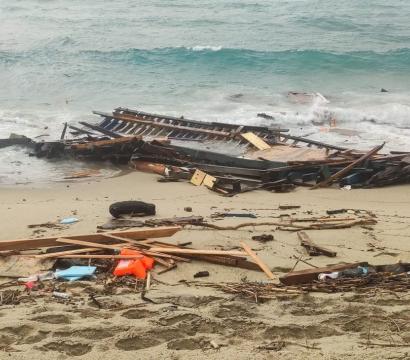Bord de plage où se situent des débris de bois et de plastique.