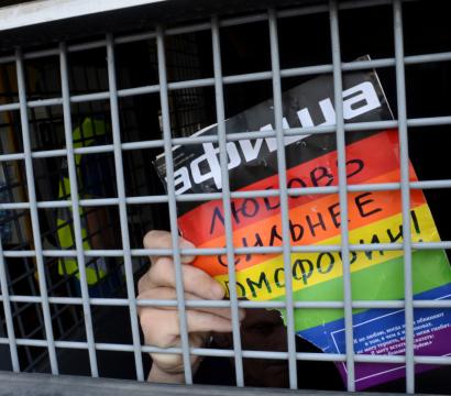 Affiche aux couleurs de la communauté LGBTI déchirée avec du texte en russe.