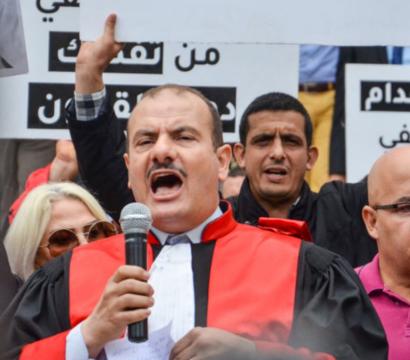 Homme qui parle dans un micro avec une robe de juge