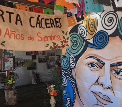 Murale avec un visage de femme et banderole avec un message rappelant la mort de Berta.