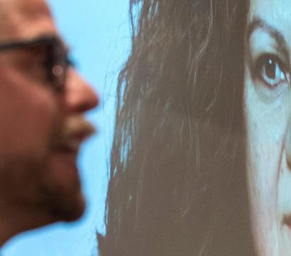 On voit le visage de la militante sur un écran géant