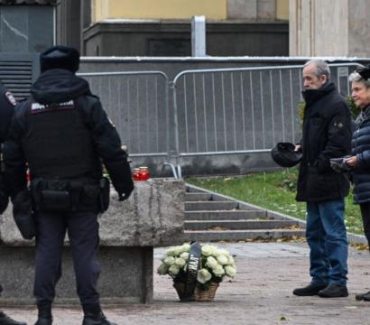 Des policiers se tiennent devant des lampions et des fleurs