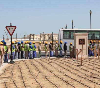 Des travailleurs sont en file pour prendre un autobus