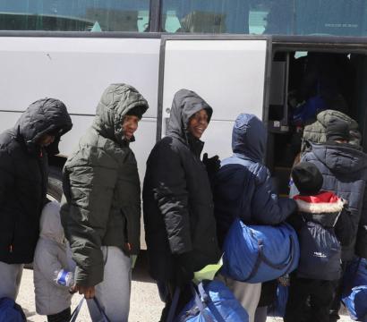 Des migrants montant dans un autobus