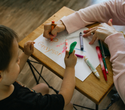 femme qui dessine avec un enfant dans une garderie