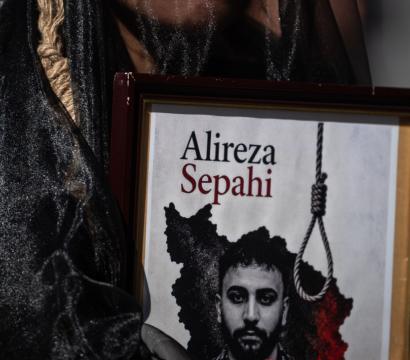 La photo montre un manifestant tenant un portrait de Alireza Sepahi, un manifestant iranien de 25 ans. Celui-ci a été arrêté lors des manifestations anti-régime de janvier 2026 à Ispahan.